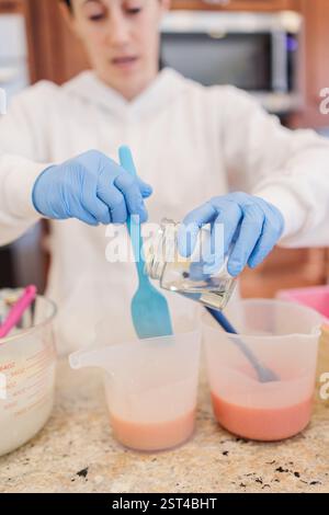 Nahaufnahme einer Frau, die der handgemachten Seifenmischung in Stow Duft zufügt. Stockfoto