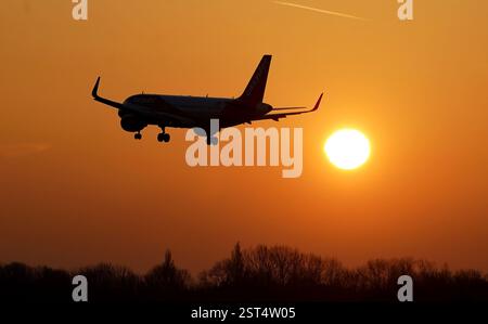 Ein EasyJet-Flugzeug landet am Flughafen London Gatwick, während die Sonne über Crawley, West Sussex, aufgeht. Bilddatum: Montag, 17. Februar 2025. Stockfoto