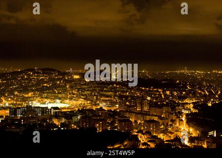Barcelona Stadtbild bei Nacht von einem hohen Aussichtspunkt aus. Beleuchtete Stadt, dunkler Himmel und Panoramablick. Stockfoto