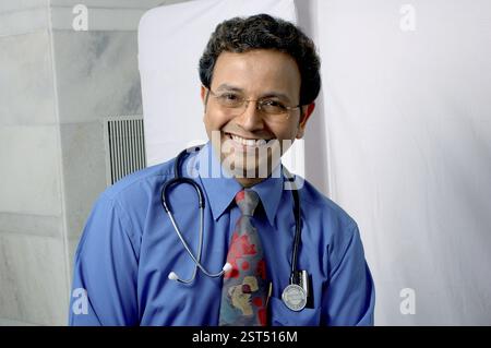 Junger indischer Arzt lächelt mit Stethoskop im Klinikkrankenhaus Stockfoto
