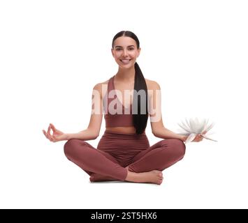 Frau, die Yoga übt mit schöner Lotusblume in der Hand auf weißem Hintergrund. Padmasana (Lotusposition) Stockfoto