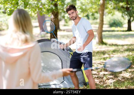 Ein junges Paar spielt Badminton auf dem Campingplatz Stockfoto