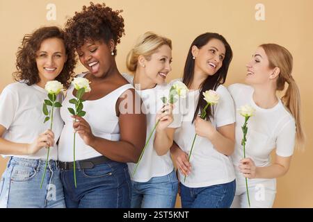 Glückliche gemischte Frauen, die Blumen in der Halle halten Stockfoto