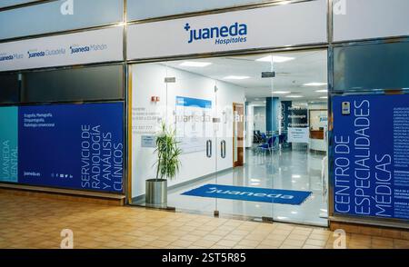 Inca, Mallorca - Spanien, 5. Juli 2024: Der Eingang zum Juaneda Krankenhaus in Inca, Mallorca, mit einer Glastür, blauer Beschilderung für medizinische Fachrichtungen, Stockfoto