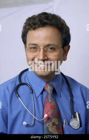 Junger indischer Arzt lächelt mit Stethoskop im Klinikkrankenhaus Stockfoto