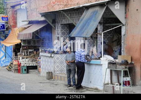 Marktszene mit Männern, die an Verkaufsständen mit Lebensmitteln und traditionellen Waren arbeiten, am Tichka-Pass, Col du Tichka, 2260 m, Marokko, Afrika Stockfoto