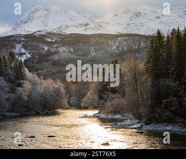 Wintersonnenaufgang über dem ungefrorenen Litjelva-Fluss. Malerischer Morgenblick auf Brøstadbotn, Norwegen, Nordeuropa Stockfoto