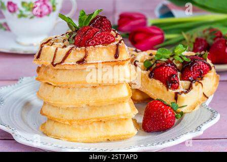 belgische Waffeln in Herzform, dekoriert mit frischen Erdbeeren Stockfoto