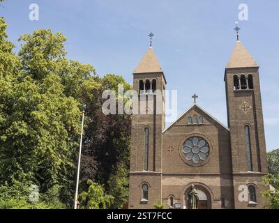 Kirche mit zwei Glockentürmen und rundem Fenster bei sonnigem Tageslicht, Ulft, gelderland, niederlande Stockfoto