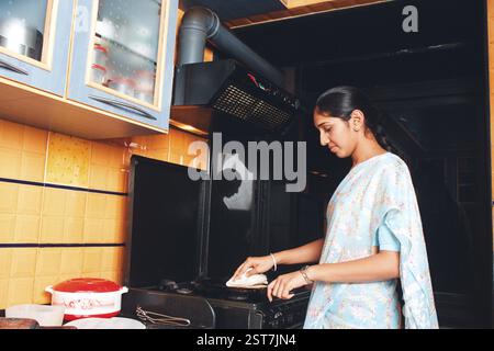 Südasiatische Indianerin, die in der Küchenreinigung arbeitet Stockfoto