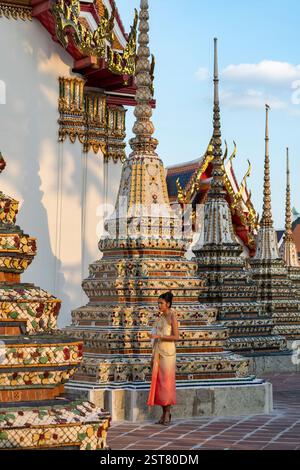 Thailändische Frau in traditioneller Kleidung posiert für ein Foto in der Gegend von Khao Mor im Wat Pho Tempel, Bangkok, Thailand Stockfoto