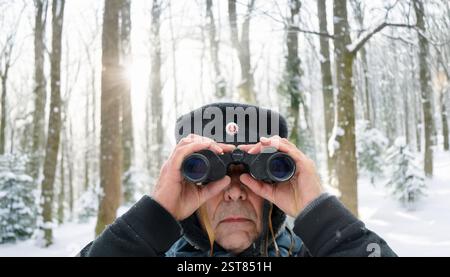 Blick durch ein Fernglas, alte DDR-Garde Hut Mann Stockfoto
