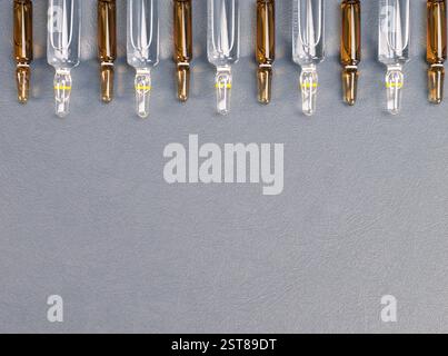 Ampullen mit Medizin auf grauem Hintergrund. Pharmazeutische Produkte, Impfung und Schönheitskonzept. Stockfoto