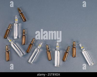 Ampullen mit Medizin auf grauem Hintergrund. Pharmazeutische Produkte, Impfung und Schönheitskonzept. Stockfoto
