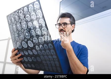 Allgemeinarzt, der sich die MRT des menschlichen Gehirns ansieht und Anatomie und Pathologie des Gehirns des Patienten während des Krankenhauses untersucht Stockfoto