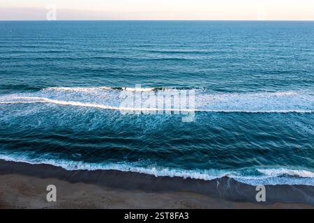 Aus der Vogelperspektive über die Wellen, die am Strand in Kill Devil Hills North Carolina bei Sonnenuntergang brechen Stockfoto