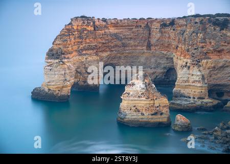 Klippen, Felsformationen und Naturbögen am Strand La Marina bei Sonnenuntergang in der Algarve in der Nähe der Städte Albufeira und Portimao. Portugal. Stockfoto