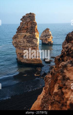 Felsformationen am Strand La Marina bei Sonnenuntergang in der Algarve in der Nähe der Städte Albufeira und Portimao. Portugal. Stockfoto