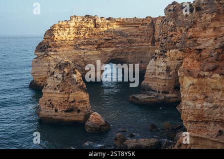 Klippen, Felsformationen und Naturbögen am Strand La Marina bei Sonnenuntergang in der Algarve in der Nähe der Städte Albufeira und Portimao. Portugal. Stockfoto