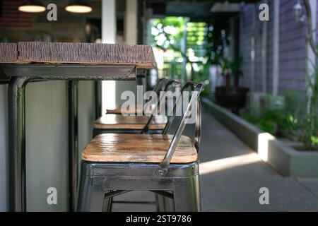 Bartheke aus Holz mit hohen Hockern. Nahansicht. Stockfoto