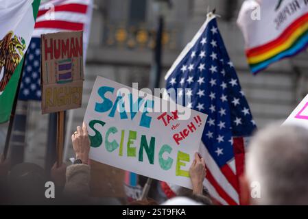 San Francisco, Kalifornien, USA, 17. Februar 2025. Demonstranten tragen Fahnen und Schilder mit der Aufschrift „Rettet die Wissenschaft, besteuert die Reichen!!!“ Und "Human = Rights" im Rathaus von San Francisco am Präsidenten-Tag. Shelly Rivoli/Alamy Stockfoto