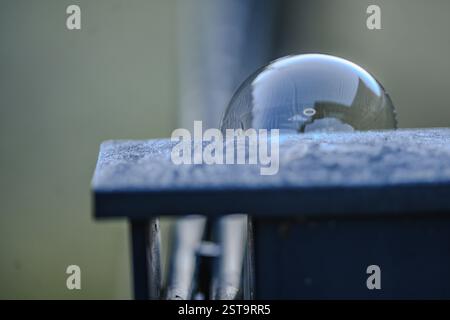 Nahaufnahme einer Seifenblase mit Lichtreflexionen auf einer glatten Oberfläche Stockfoto