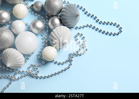 Silberne Weihnachtskugeln mit Perlen auf blauem Hintergrund Stockfoto