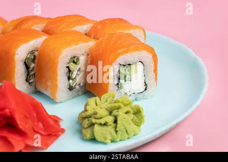 Japanisches Speisekonzept. Sushi-Brötchen Philadelphia mit Lachs und Frischkäse auf einem Teller mit Ingwer und Wasabi. Sushi-Menü. Traditionelle japanische Küche Stockfoto