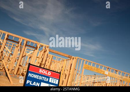 Immobilienschild im neuen Haus, das Baustelle gegen Deep Blue Sky umrahmt. Stockfoto