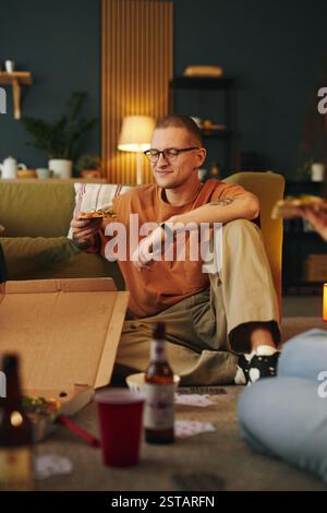 Genießen Sie die abendliche Pizza mit Freunden im gemütlichen Wohnzimmer Stockfoto