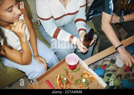 Genießen Sie Pizza und Getränke mit Freunden in gemütlicher Umgebung Stockfoto