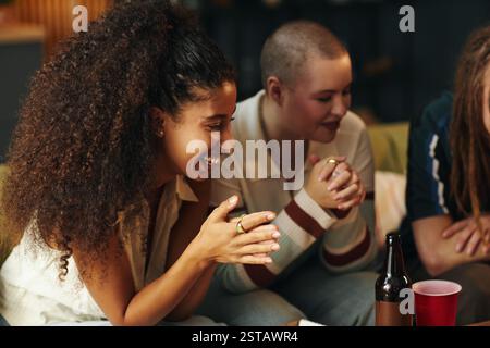 Gruppe von Freunden, die in gemütlicher Umgebung sitzen und sich unterhalten Stockfoto