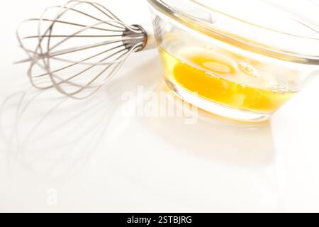 Handmixer mit Eiern in Glasschale Stockfoto