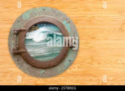 Antikes Bullauge mit Blick auf abstürzende Wellen auf einem Bambuswall Hintergrund. Stockfoto