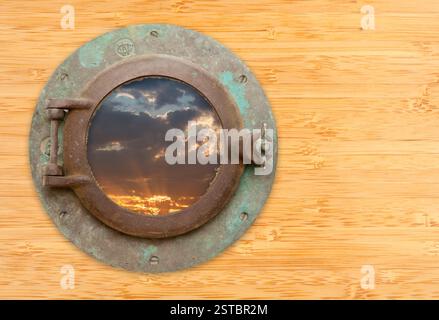 Antikes Bullauge mit Blick auf den Sonnenuntergang an der Bambuswand Stockfoto
