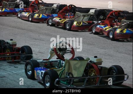 Im pulsierenden Miami stehen auf einer gepflasterten Rennstrecke eine Reihe farbenfroher Gokarts, die in der Sonne glänzen. Diese potenziellen Champions warten auf das Startzeichen Stockfoto