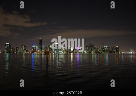 Miami Skyline bei Nacht. Beleuchtete Wolkenkratzer mit bunten Lichtern, die im Wasser reflektiert werden. Geschäftige Metropole, urbane Landschaft. Stadt, die nie schläft Stockfoto