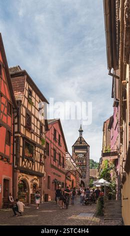 Hauptstraße mit historischen Häusern und Blick auf den Torturm Dolder in der Altstadt von Riquewihr, Elsass, Frankreich Stockfoto