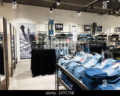 Lviv, Ukraine - 16. Februar 2025: New Yorker Einzelhandelsgeschäft mit verschiedenen Denim-Jeans-Styles und Preisen auf übersichtlichen Displays. Stockfoto