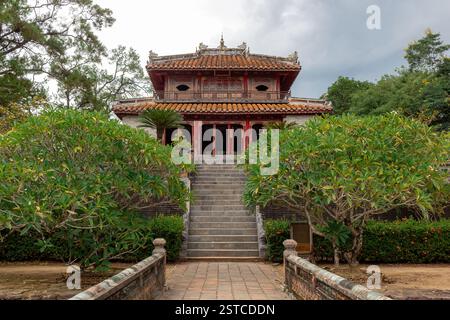 Farbenfrohe, traditionelle Baugrabstruktur umgeben von üppig grünen Wäldern am Mausoleum von Kaiser Minh Mang in Hue Vietnam Stockfoto