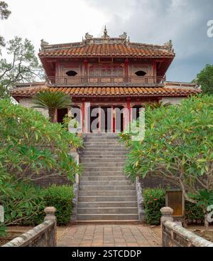 Farbenfrohe, traditionelle Baugrabstruktur umgeben von üppig grünen Wäldern am Mausoleum von Kaiser Minh Mang in Hue Vietnam Stockfoto