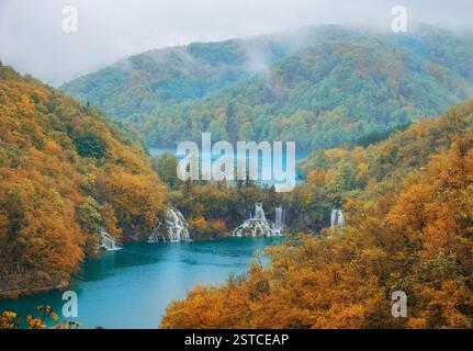 Neblige Herbstlandschaft der Plitvicer Seen, Kroatien, mit türkisfarbenem Wasser, kaskadierenden Wasserfällen und lebhaftem Herbstlaub in einer ruhigen Umgebung Stockfoto