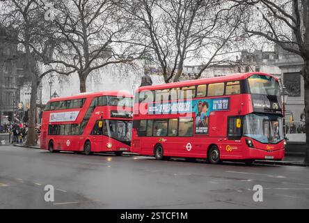 Traditionelle rote Doppeldeckerbusse verkehrten entlang einer Straße im Zentrum Londons. Foto in London, Großbritannien, an einem bewölkten Tag Stockfoto