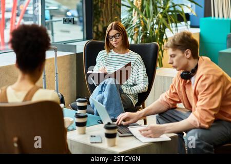 Drei Kollegen führen konzentrierte Gespräche, während sie in der Lounge des Hotels Drinks genießen. Stockfoto