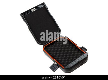 Offener tragbarer schwarzer Safe mit orangefarbenem Futter, Schaumstoffinnenraum zur Aufbewahrung von Waffen oder Wertsachen, isoliert auf weißem Hintergrund. Stockfoto
