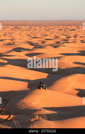 Mann sitzt auf einem Quad in den Dünen der Sahara in Tunesien Stockfoto