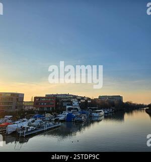 Ein atemberaubend schöner Sonnenuntergang über einem ruhigen und ruhigen Hafen mit zahlreichen Booten, die anmutig im Hannover Mittellandkanal angedockt sind Stockfoto