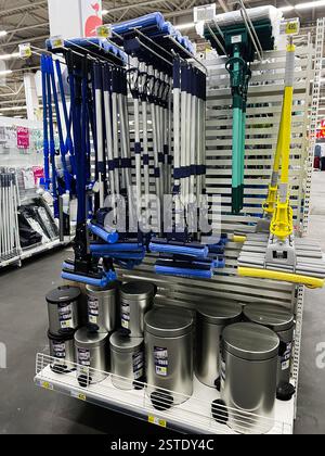 Lviv, Ukraine - 16. Februar 2025: Verschiedene Reinigungsgeräte und Metallabfallbehälter werden in einem Ladenregal ausgestellt. Stockfoto