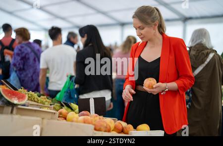 Eine Frau wählt Äpfel auf dem Markt. Stockfoto