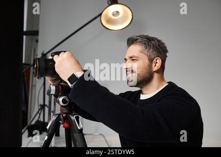 Ein geschickter Mann stellt seine Kamera so ein, dass er wunderschöne Momente bei hellem Licht einfängt. Stockfoto